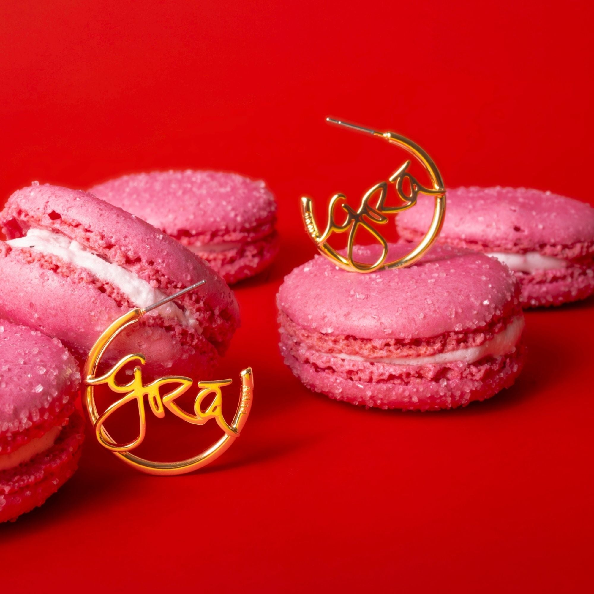 Gold Gra Beag Hoop Earrings on Pink Macarons  