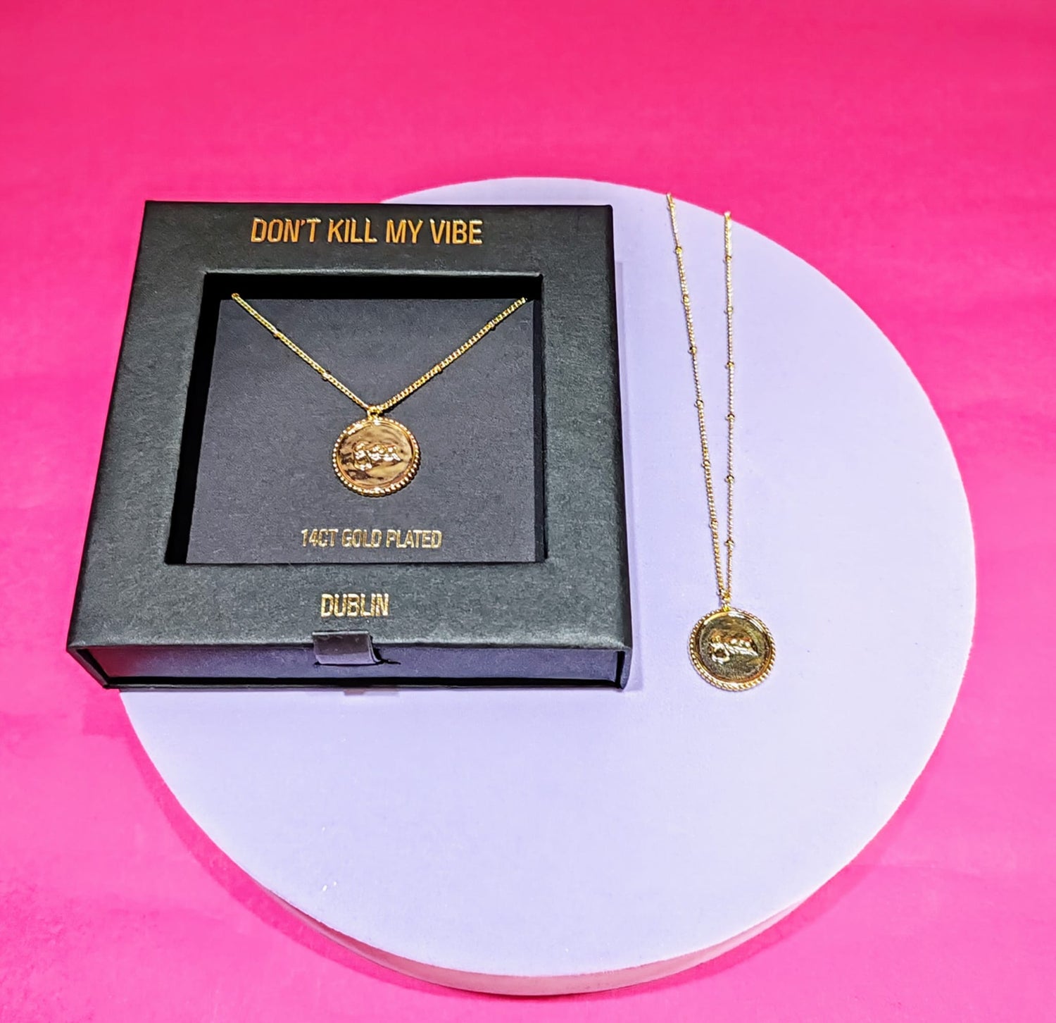 Grá Medallion Gold Necklaces one on a tray and one in a gift box 